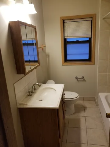 a bathroom with a toilet a sink and mirror