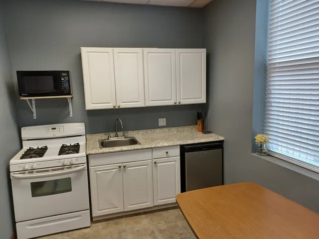 a kitchen with granite countertop a stove sink and cabinets