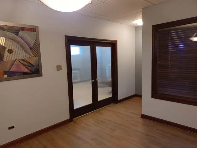 a view of an empty room with wooden floor and closet