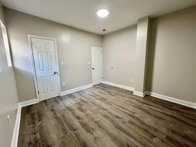 an empty room with wooden floor and sliding door
