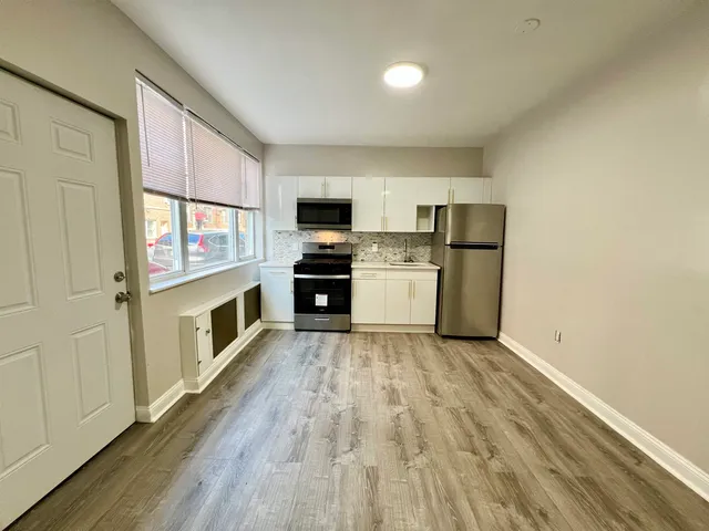 a kitchen with stainless steel appliances a stove top oven a sink and a refrigerator