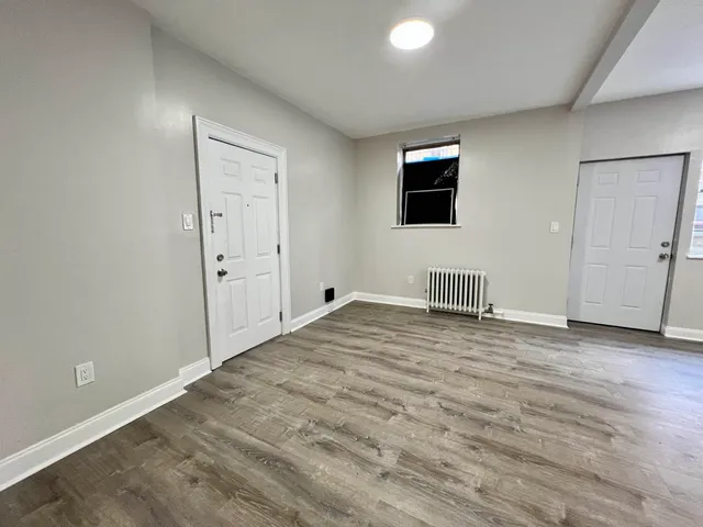 a view of a livingroom with wooden floor and a flat screen tv