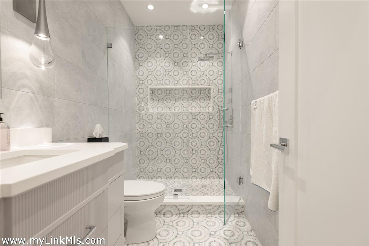 37 Sankaty Head Road Nantucket, MA 02554 - Photo 45 of 65 a bathroom with a granite countertop sink a toilet and shower