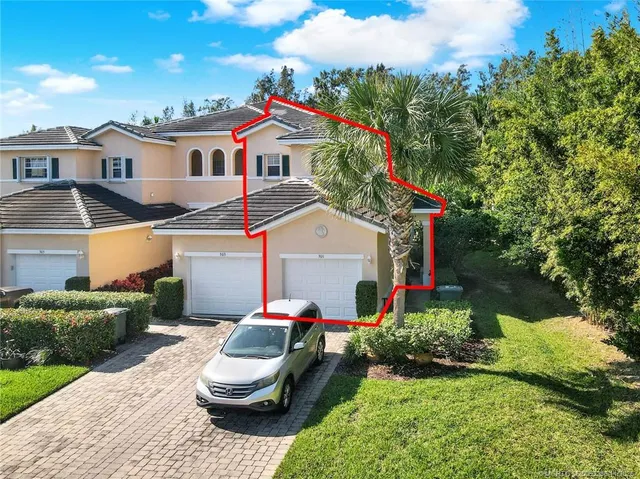 a view of a white house with a yard and potted plants
