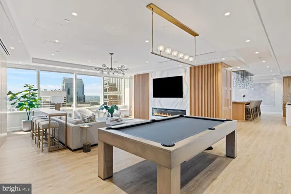 a living room with furniture large window and wooden floor