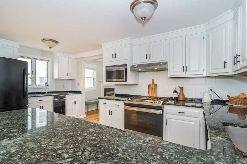 15 Nimitz Circle Natick, MA 01760 - Photo 7 of 21 a kitchen with stainless steel appliances granite countertop a stove top oven a refrigerator a sink and dishwasher with white cabinets