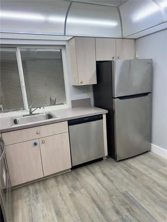 a kitchen with a refrigerator sink and cabinets
