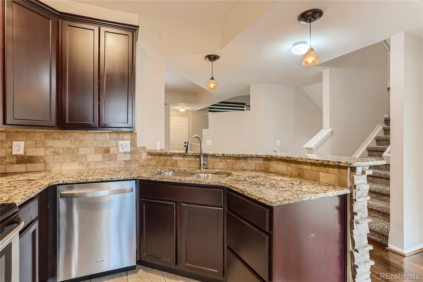 6478 Silver Mesa Drive, Unit E Highlands Ranch, CO 80130 - Photo 12 of 34 a kitchen with granite countertop cabinets stainless steel appliances a sink and wooden floor