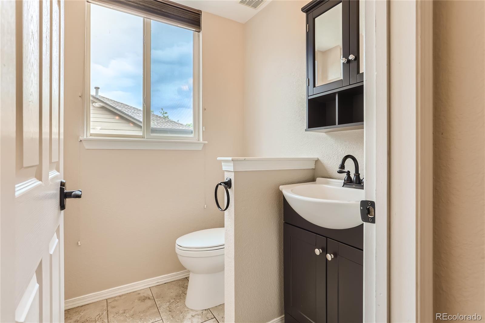 6478 Silver Mesa Drive, Unit E Highlands Ranch, CO 80130 - Photo 15 of 34 a bathroom with a toilet sink and mirror