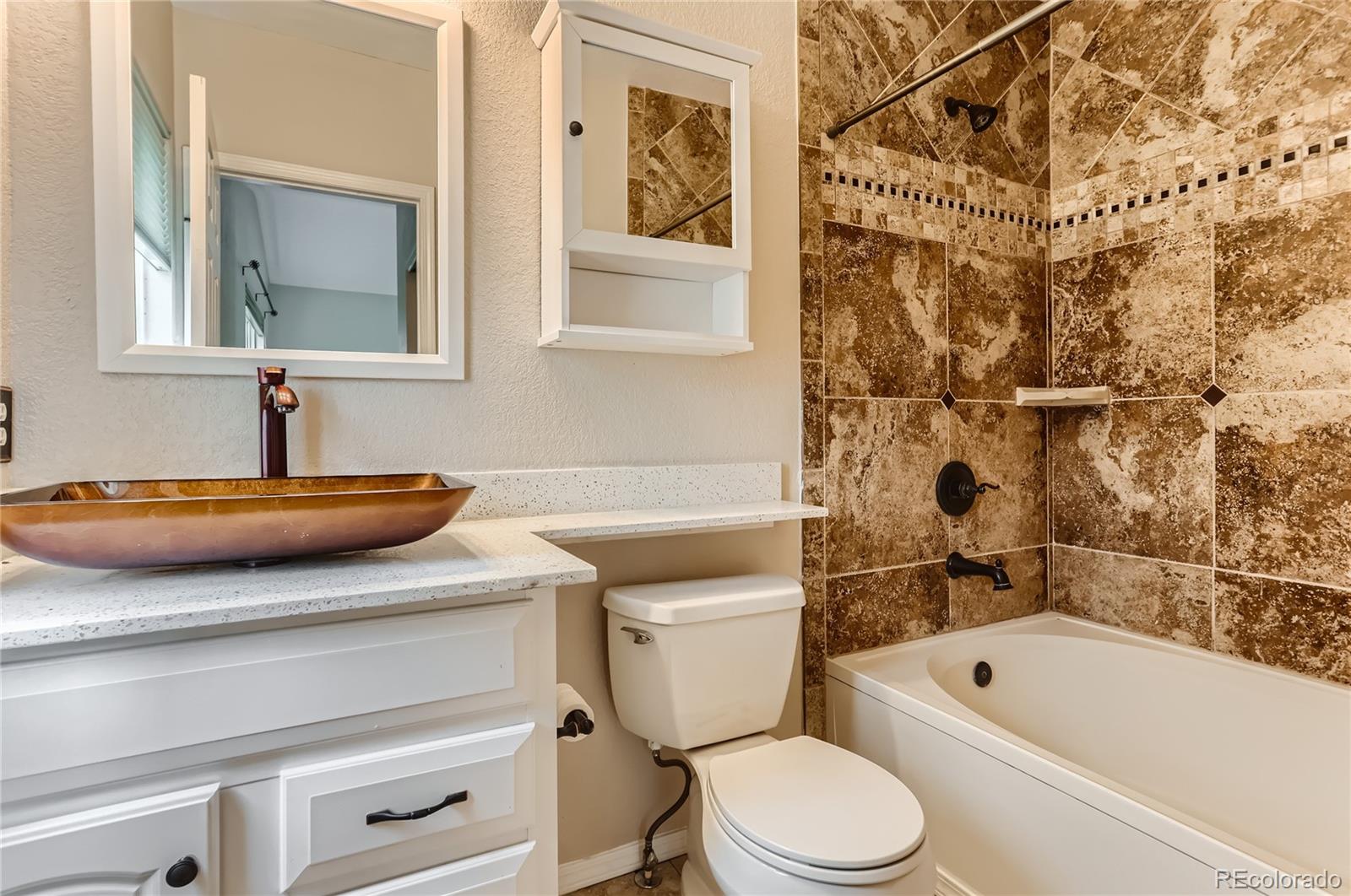 6478 Silver Mesa Drive, Unit E Highlands Ranch, CO 80130 - Photo 23 of 34 a bathroom with a sink a toilet and bathtub