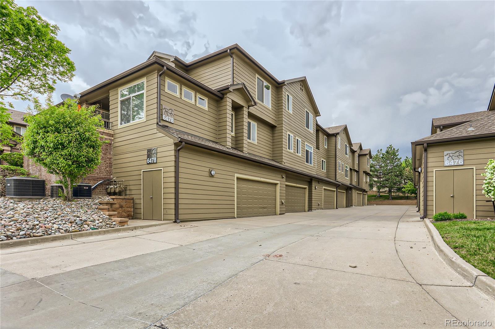 6478 Silver Mesa Drive, Unit E Highlands Ranch, CO 80130 - Photo 27 of 34 a front view of a house with a yard and garage