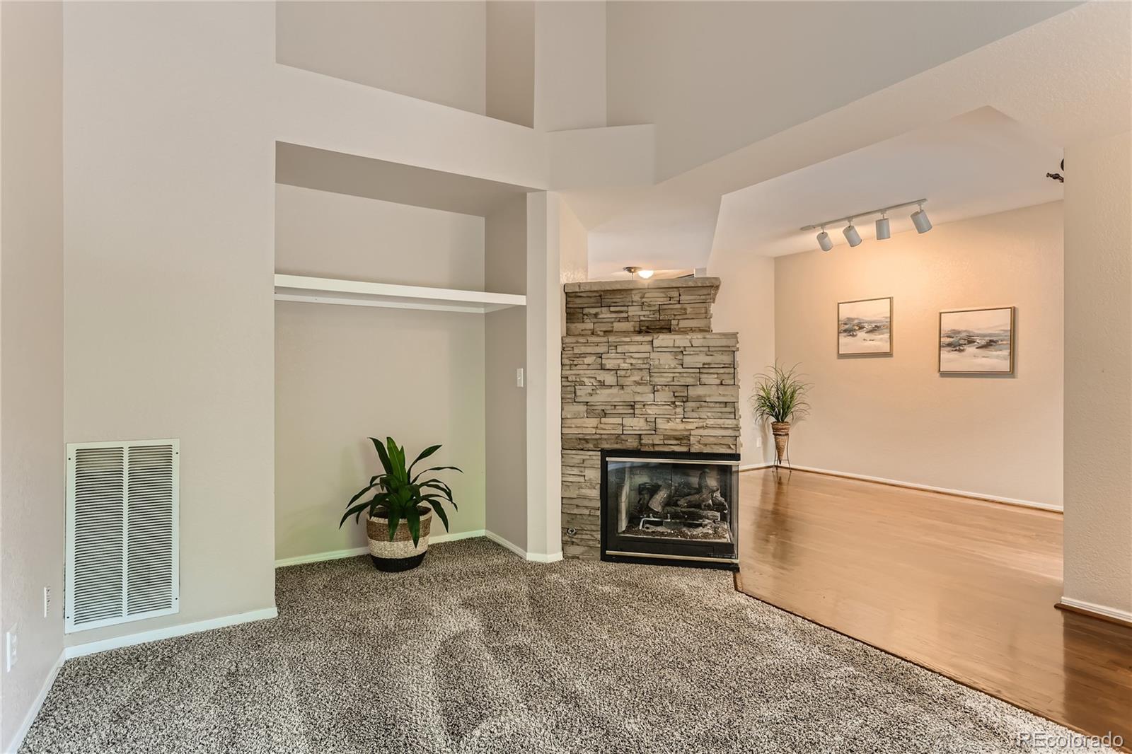 6478 Silver Mesa Drive, Unit E Highlands Ranch, CO 80130 - Photo 6 of 34 a view of empty room with a fireplace and wooden floor