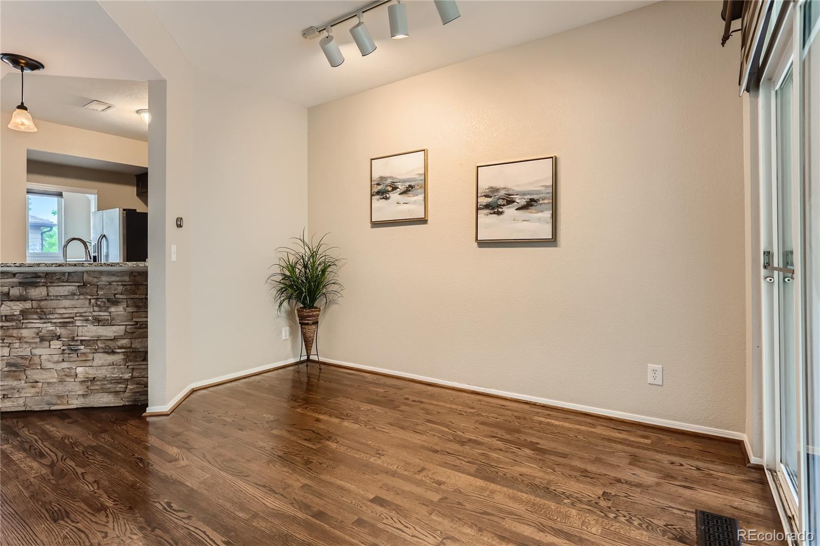 6478 Silver Mesa Drive, Unit E Highlands Ranch, CO 80130 - Photo 7 of 34 an empty room with wooden floor and cabinet