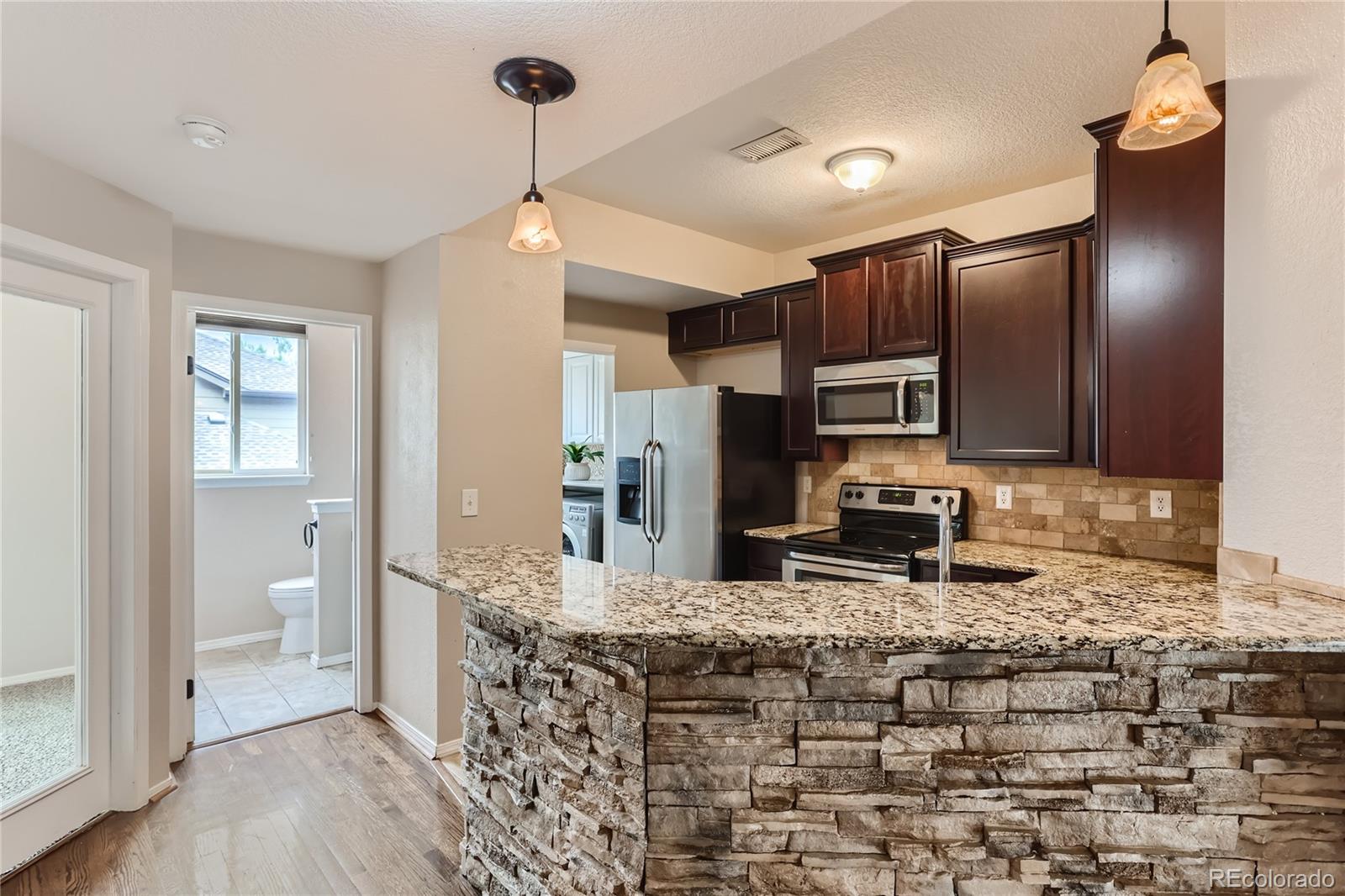 6478 Silver Mesa Drive, Unit E Highlands Ranch, CO 80130 - Photo 10 of 34 a kitchen with stainless steel appliances a sink stove and refrigerator