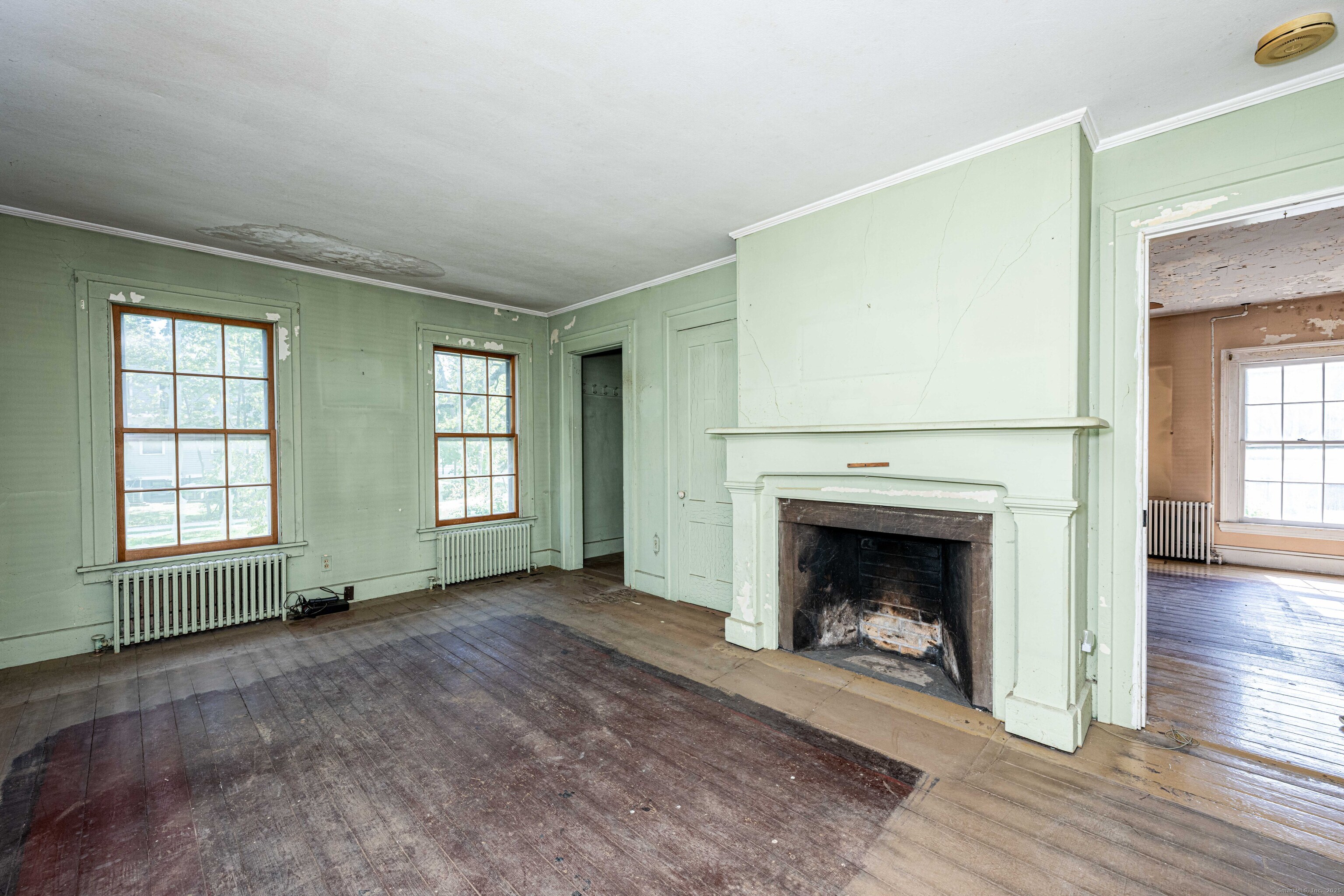 174 Whitfield Street Guilford, CT 06437 - Photo 30 of 40 an empty room with fireplace wooden floor and windows