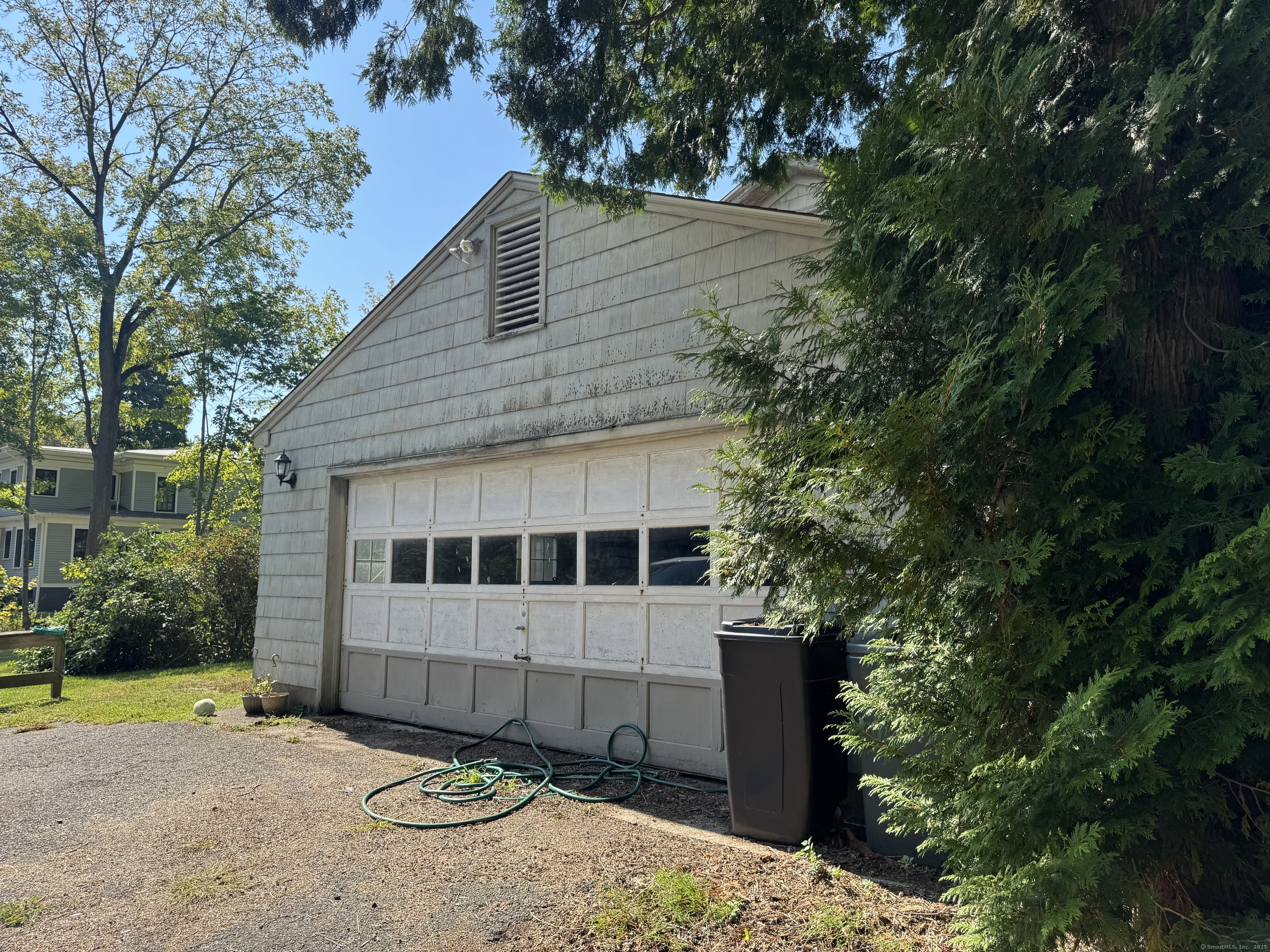 174 Whitfield Street Guilford, CT 06437 - Photo 6 of 40 a view of a small house with large trees and plants