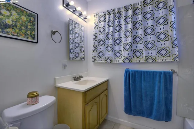 a bathroom with a sink mirror vanity and toilet