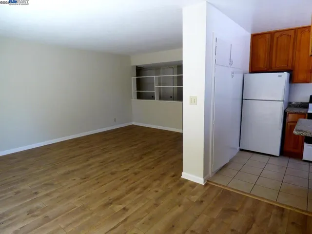 an empty room with wooden floor and cabinet