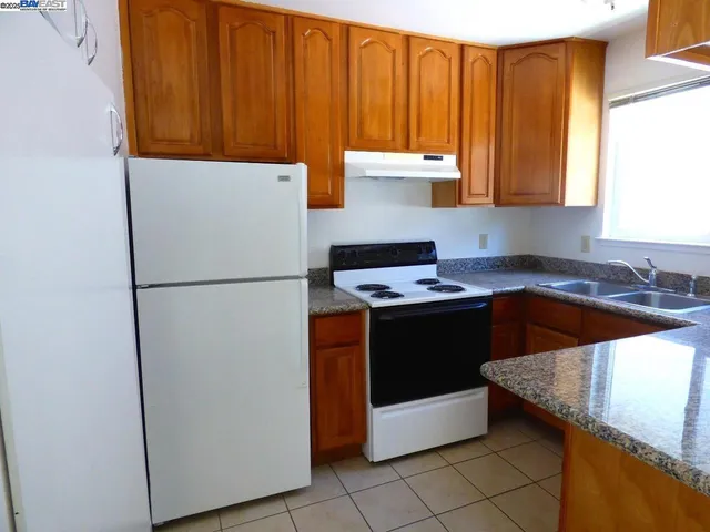 a kitchen with a refrigerator sink and cabinets