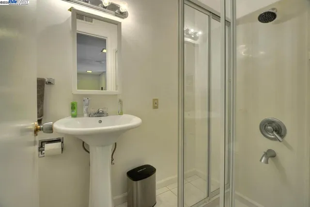 a bathroom with a sink a toilet a mirror and shower