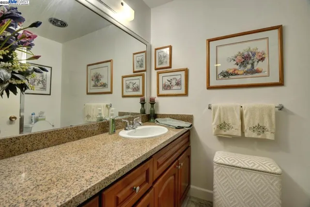 a bathroom with a granite countertop sink a mirror and vanity