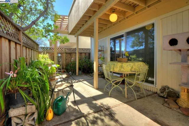a view of a patio with table and chairs potted plants with wooden fence