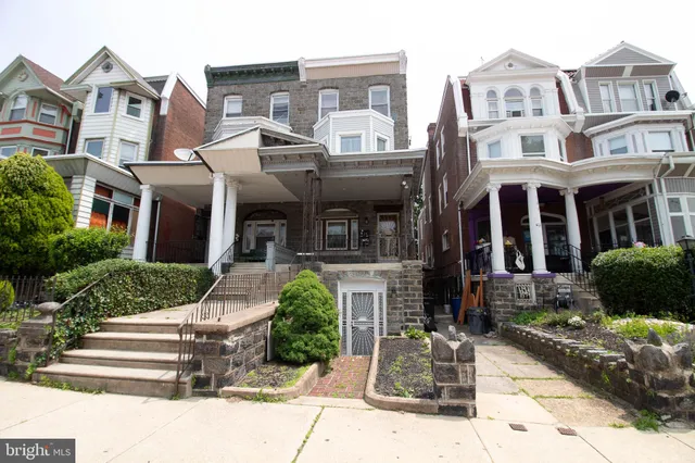 a front view of a residential apartment building with a yard