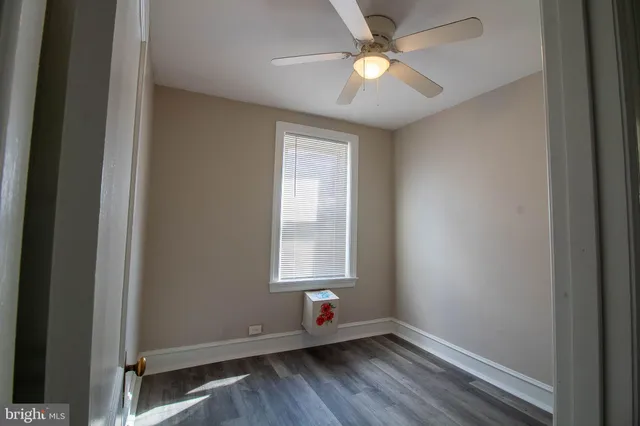 an empty room with a window and a ceiling fan