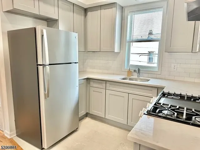 a kitchen with a refrigerator a sink and a window