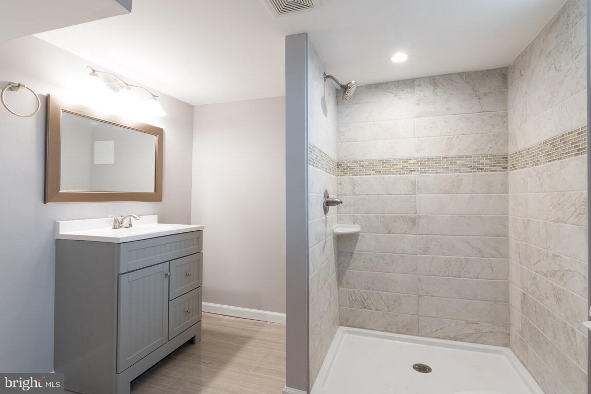 3613 Forest Hill Road Baltimore, MD 21207 - Photo 20 of 27 a bathroom with a shower sink and mirror