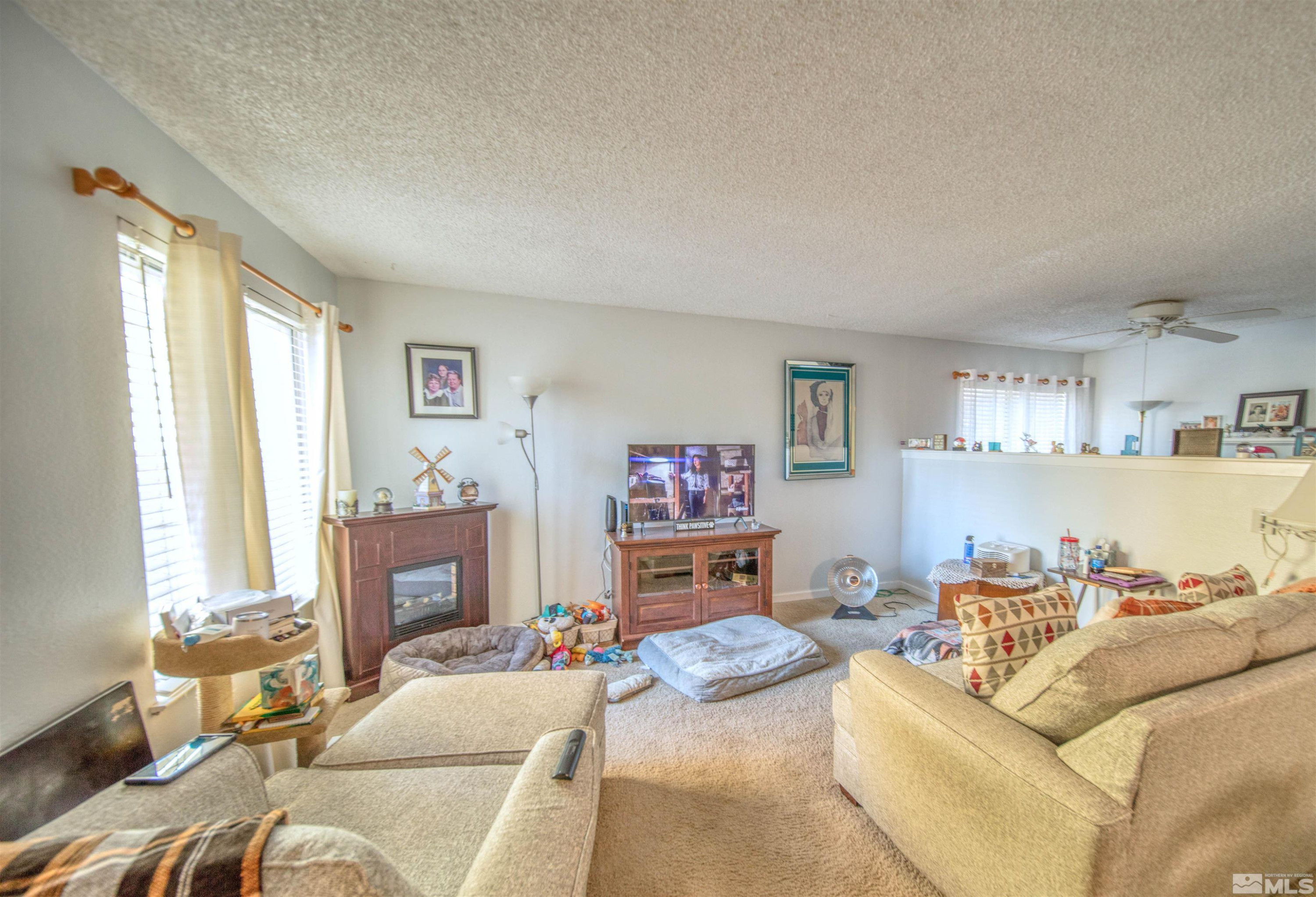 6480 Lotus Street Reno, NV 89506 - Photo 7 of 22 a living room with furniture a flat screen tv and a fireplace