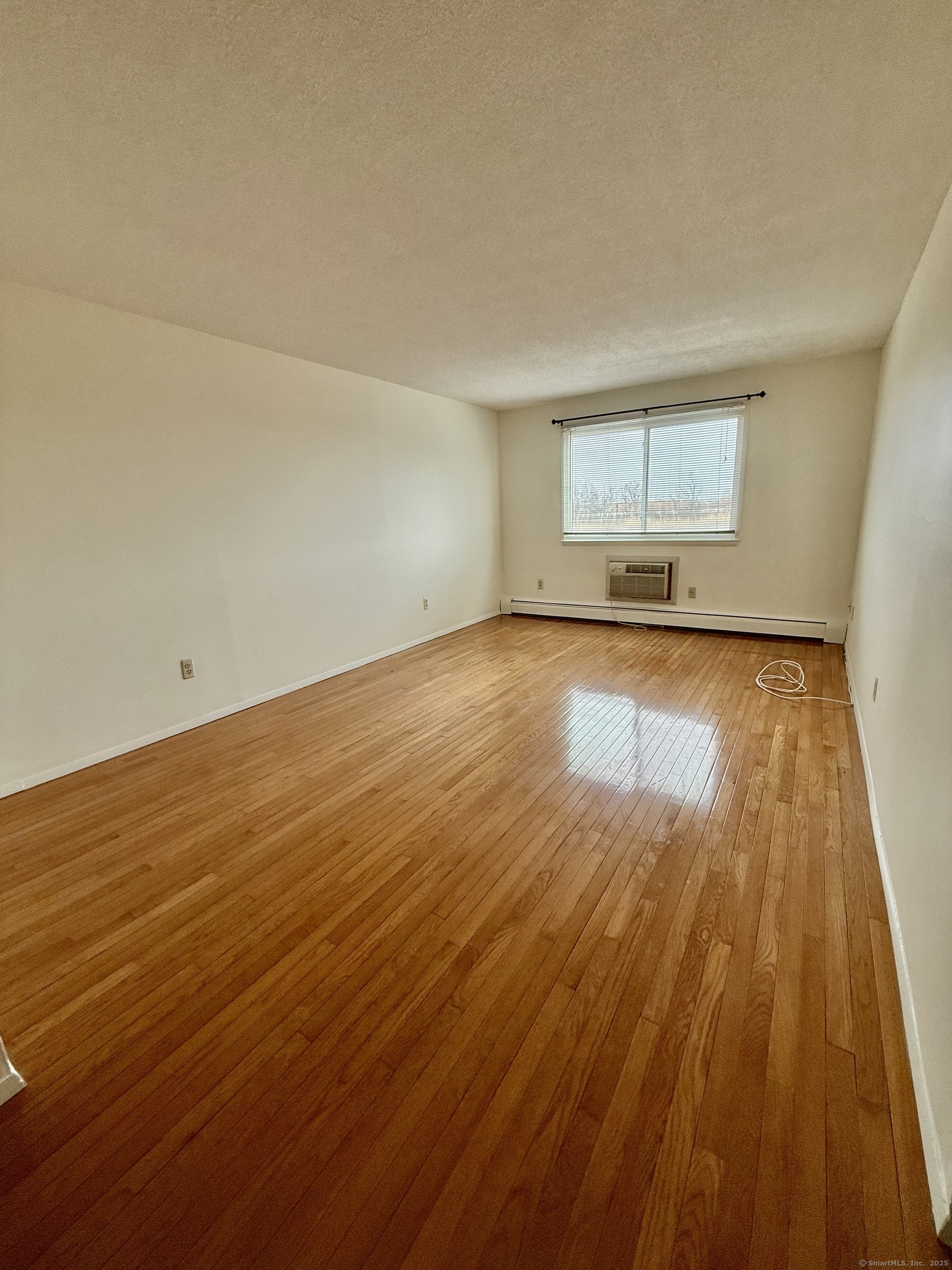 1168 Main Street, Unit C7 Stratford, CT 06615 - Photo 6 of 12 an empty room with wooden floor and windows