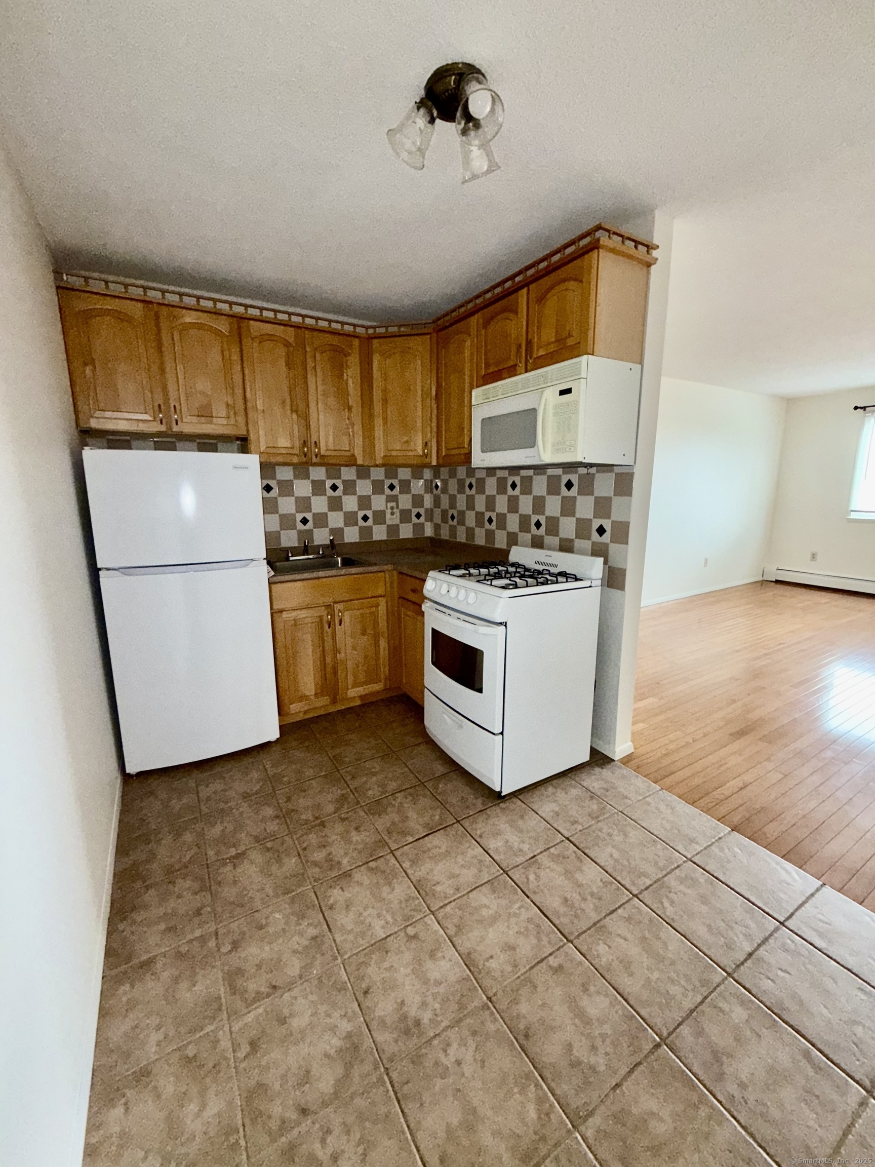 1168 Main Street, Unit C7 Stratford, CT 06615 - Photo 8 of 12 a kitchen with stainless steel appliances granite countertop a stove a sink and a refrigerator