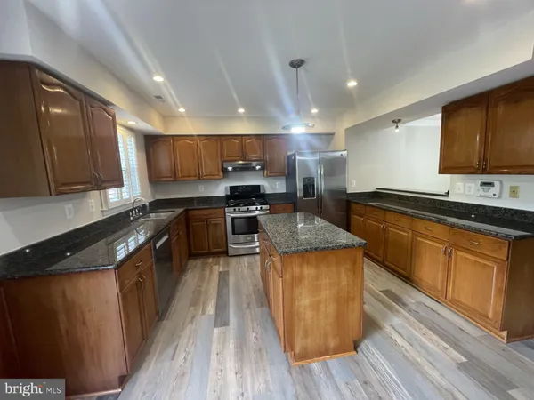 a kitchen with wooden floors and wooden cabinets