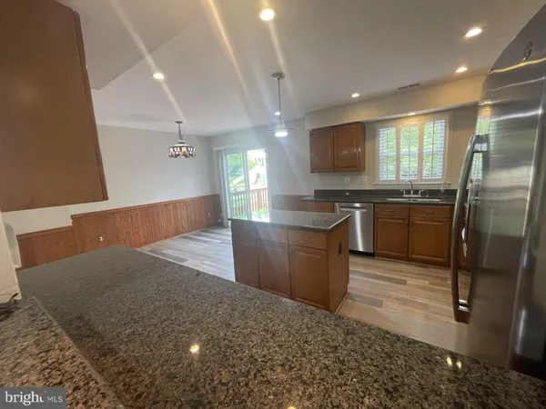 a large kitchen with stainless steel appliances a sink stove and refrigerator