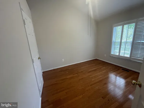 an empty room with a fireplace and wooden floor