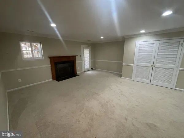 an empty room with windows and fireplace