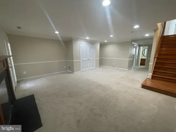 an empty room with wooden floor and stairs