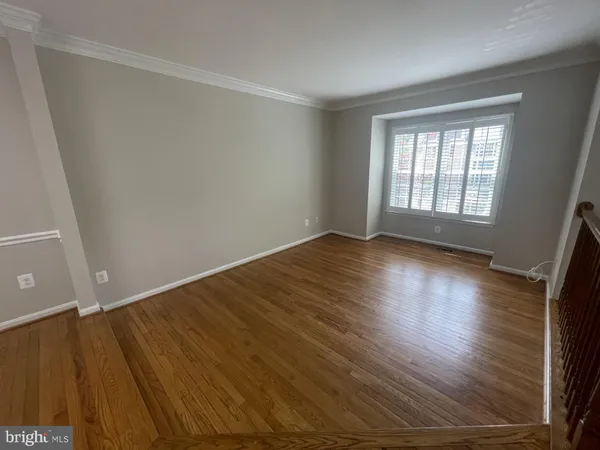 a view of room with window and wooden floor