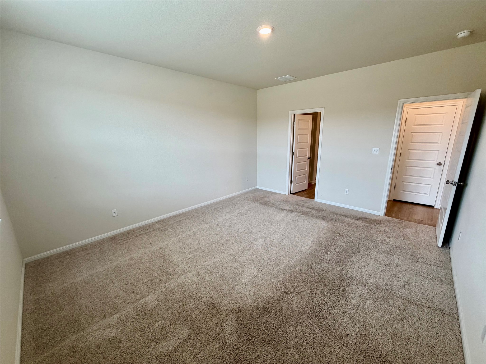 305 Tolo Drive Elgin, TX 78621 - Photo 14 of 27 Expansive carpeted room featuring light beige walls and white trim