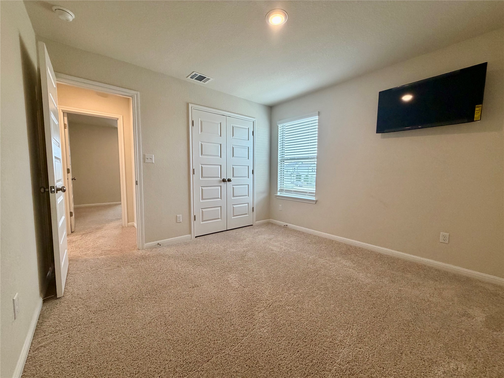 305 Tolo Drive Elgin, TX 78621 - Photo 21 of 27 Carpeted room featuring a window with horizontal blinds, overhead recessed lighting, and a bi-fold closet with panel doors