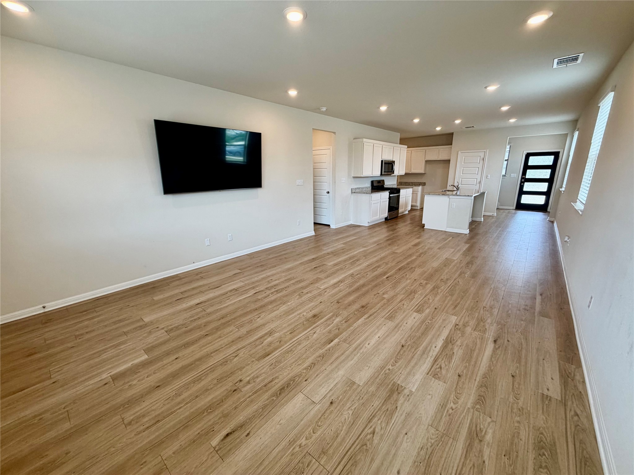 305 Tolo Drive Elgin, TX 78621 - Photo 10 of 27 Expansive open-concept room featuring light wood-finish flooring and recessed lighting