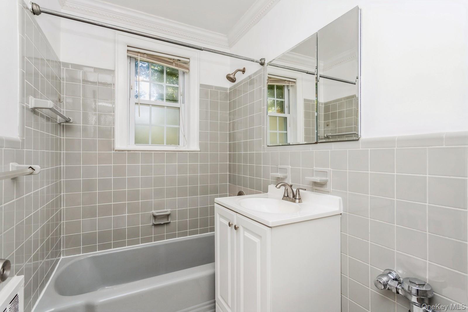 51 Cross Street, Unit 3A Yonkers, NY 10708 - Photo 11 of 17 Full bath featuring crown molding, vanity, bathing tub / shower combination, and tile walls