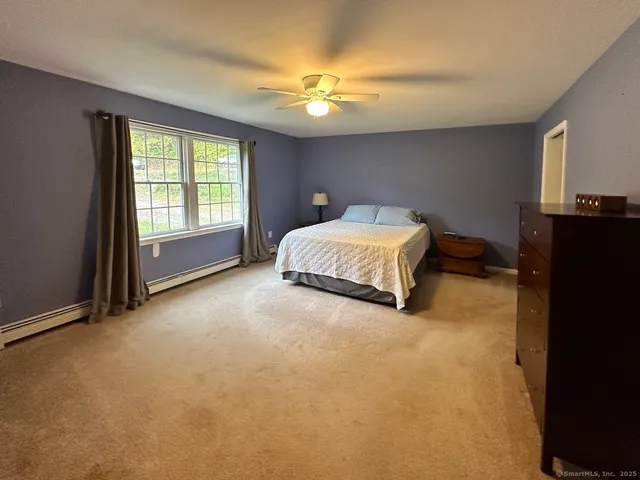 a spacious bedroom with a bed and a chandelier