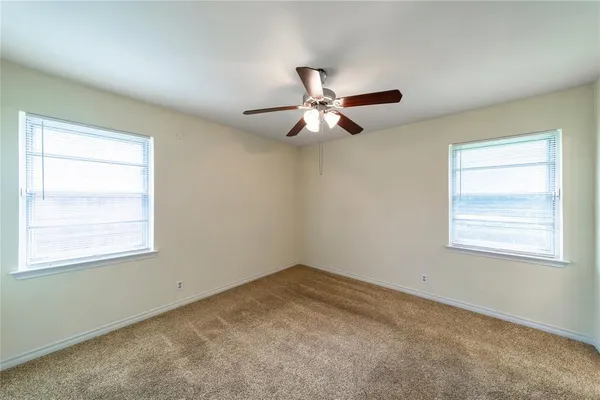 an empty room with a window and a fan