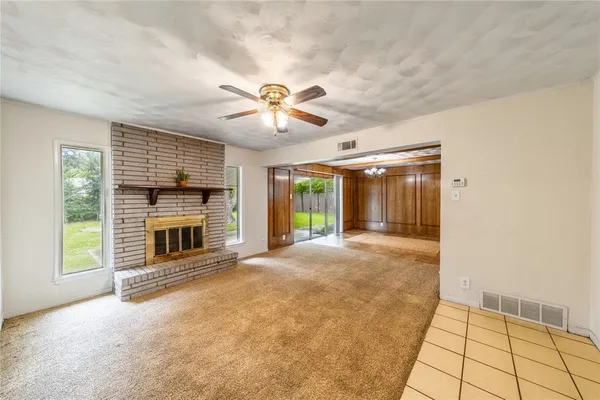a view of an empty room with a fireplace and a window