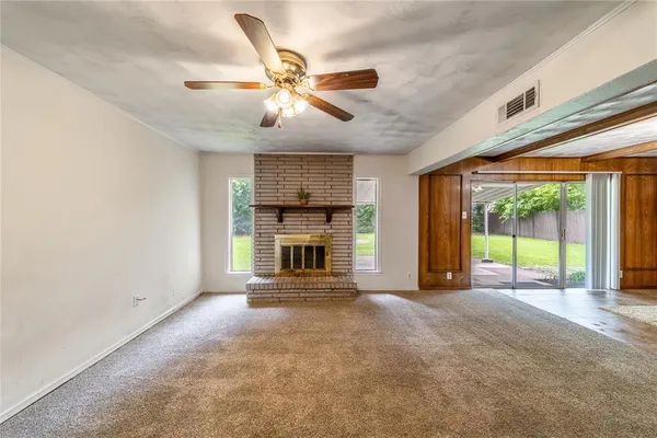 a view of an empty room with a fireplace and a large window