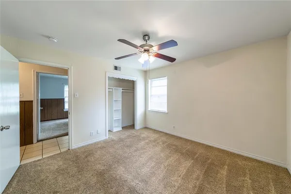 an empty room with fan and windows