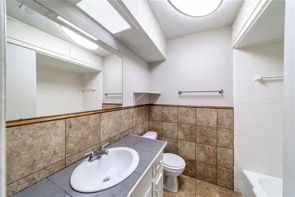 a bathroom with a sink a toilet and a mirror
