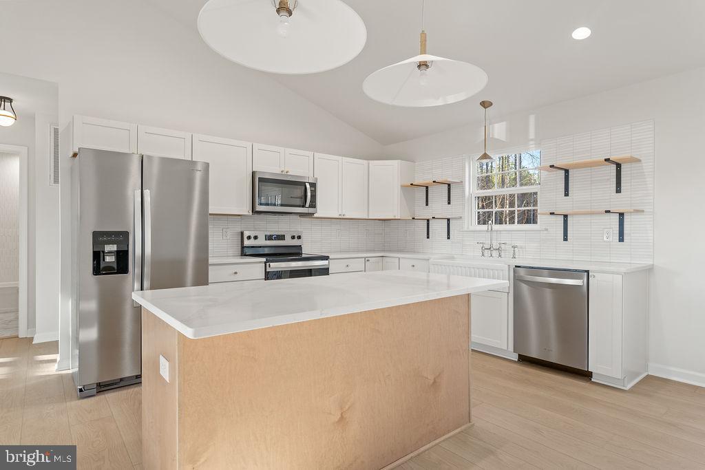 2770 Fredericks Hall Road Mineral, VA 23117 - Photo 15 of 57 a kitchen with kitchen island a sink stove and refrigerator